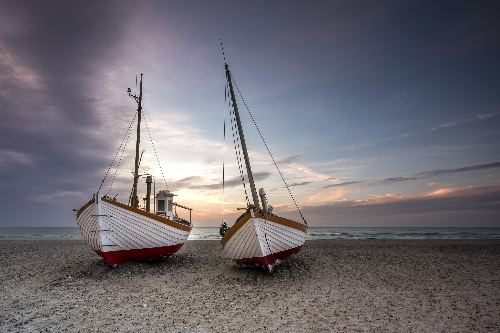 Two fishing boats on a beach in Northern Jutland during sunset