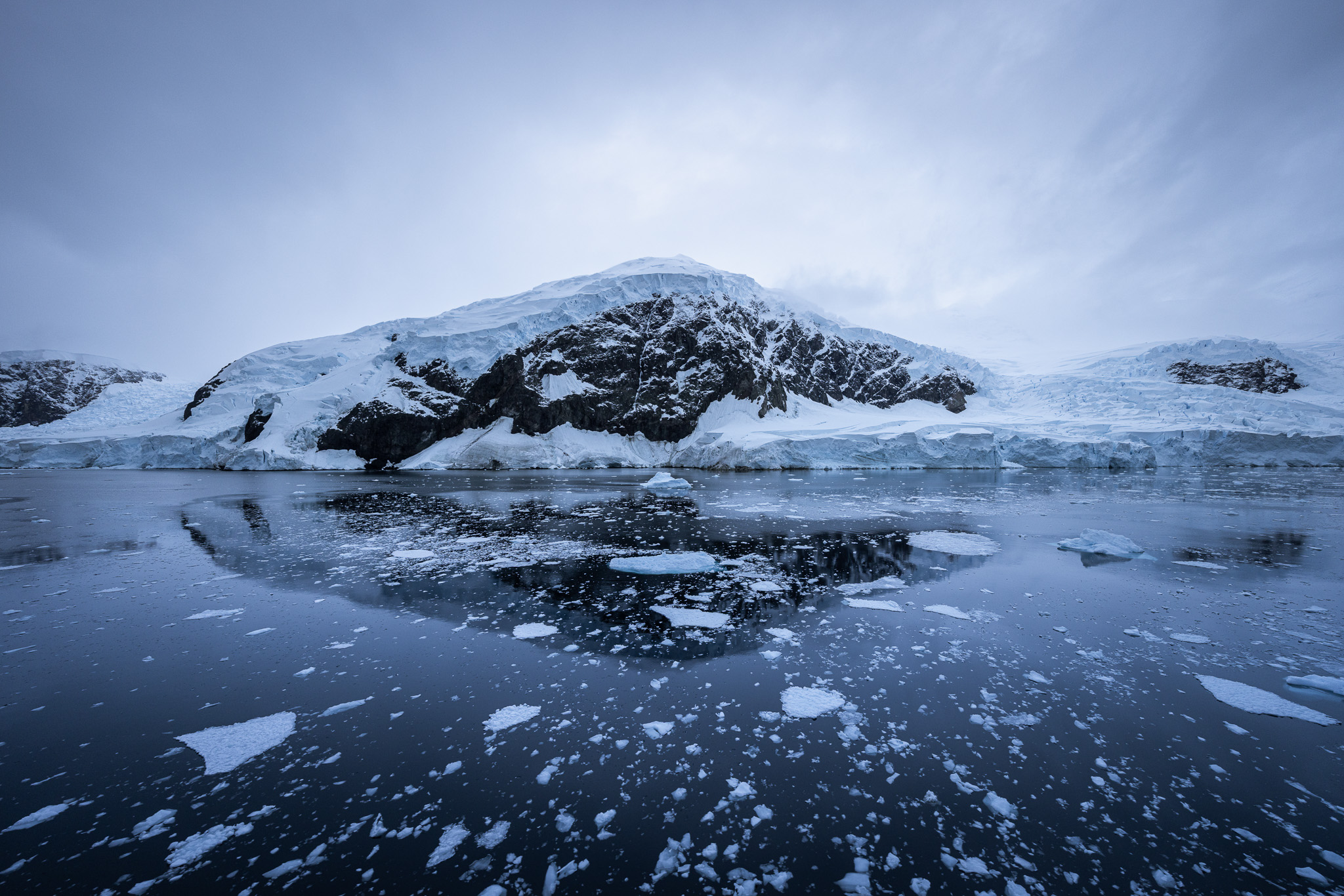 Still waters in Neko Harbour showing some reflections of the surrounding landscape
